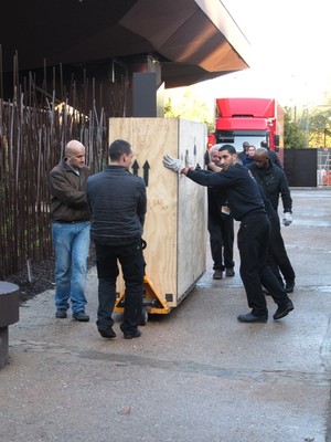 Carefully guiding the 1 tonne crates down a ramp to the footpath.